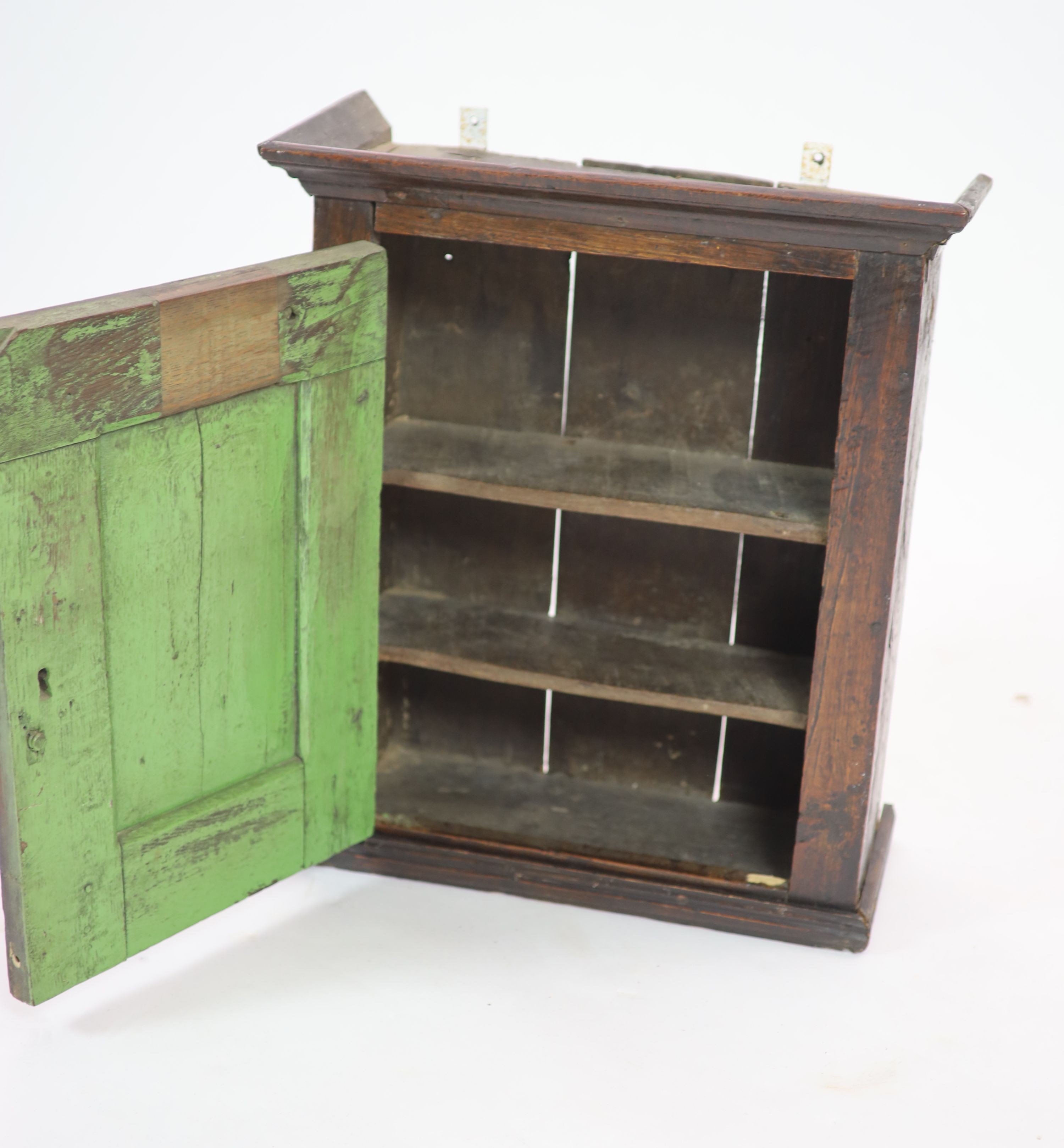A 17th century carved oak wall cupboard, H 56cm. W 49cm. D 22cm.